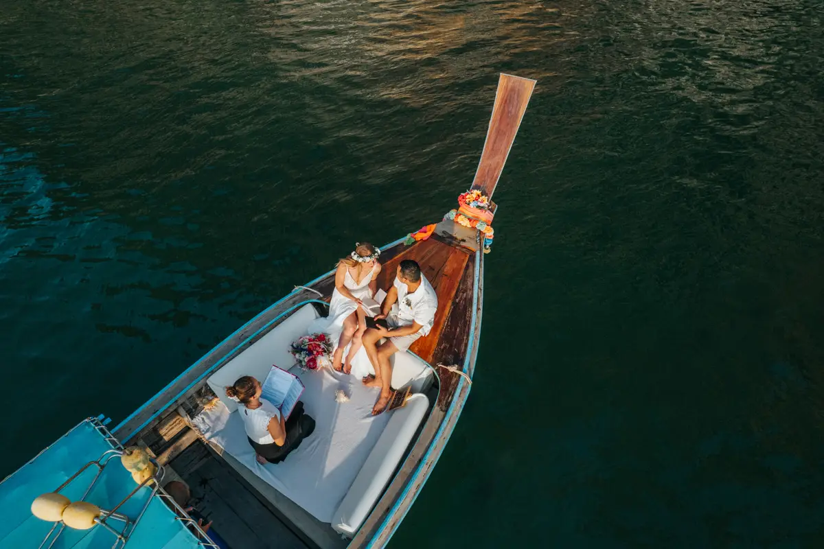 Rose and her fiancé's private wedding vows on a long-tail boat around Railay Beach , Krabi Thailand